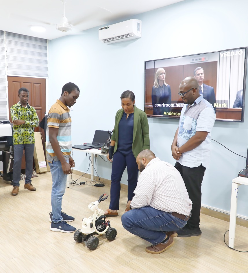 Nia Jetter (middle), Amazon Robotics AI Senior Principal Technologist and Walter Mencer (swatting), Programmes Manager,  Amazon Global Robotics, discussed a Robotic project by the KNUST College of Engineering Innovation Center.